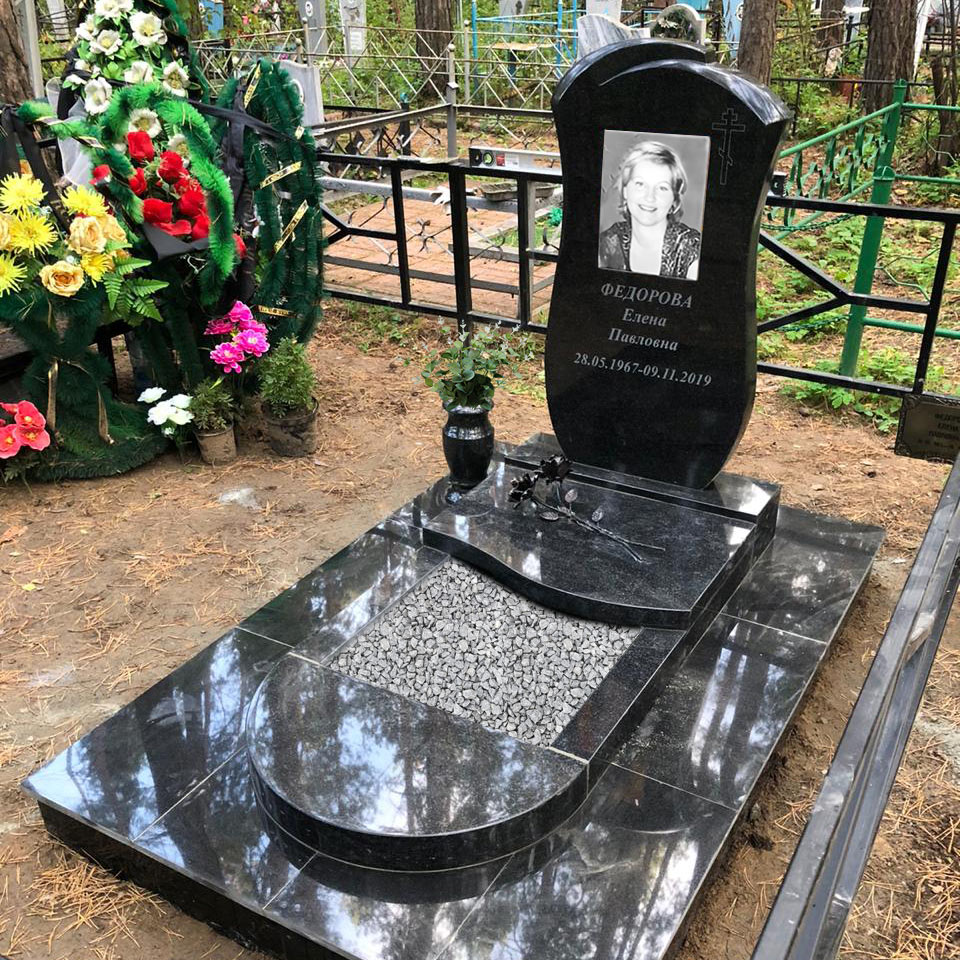 Памятник женщине в цветником и плитами