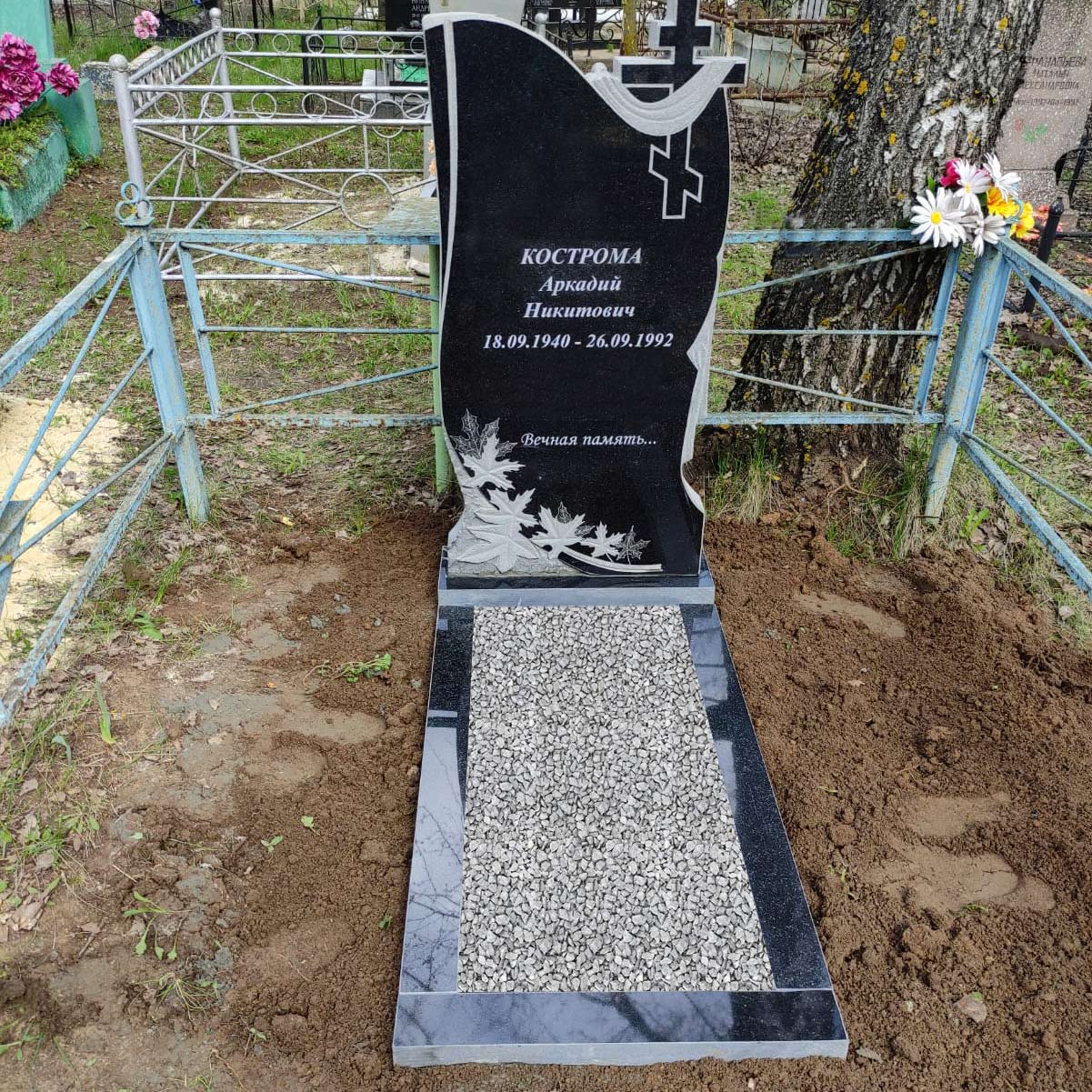 Вертикальный резной памятник с листьями и крестом