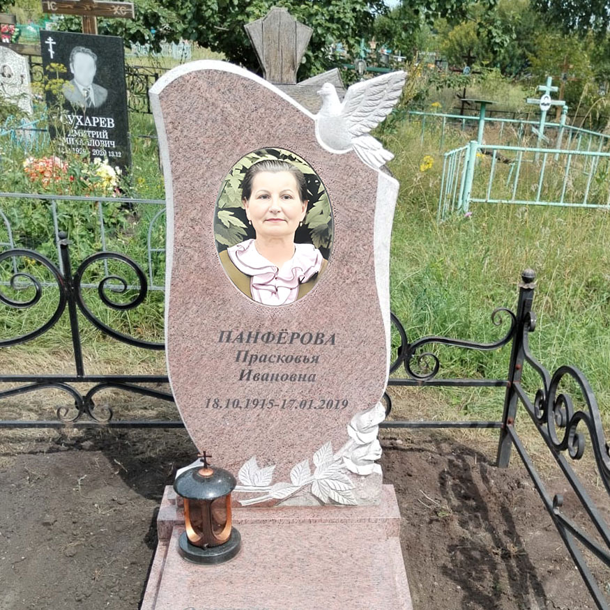 Красивая женская модель памятника из ганита габбро с цветами у основания