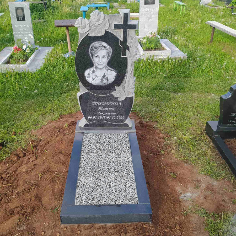 Резной памятник женщине с цветами и крестом