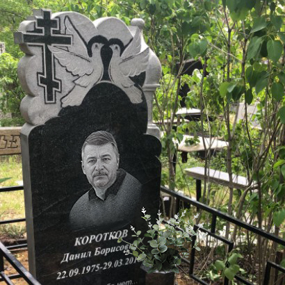 Памятник мужчине с крестом и голубями